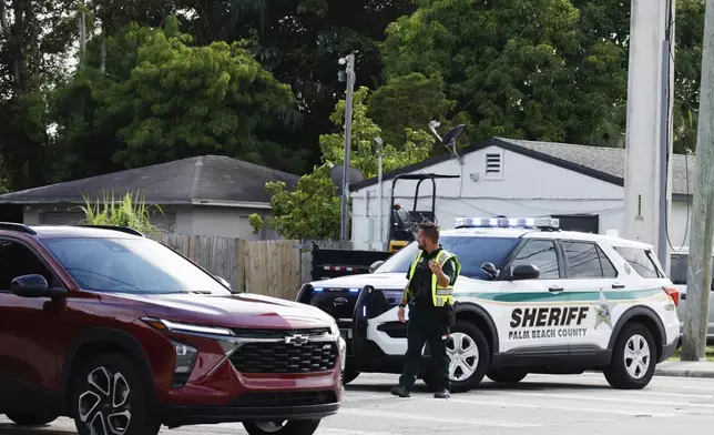 A police officer directs traffic near Trump International Golf Club after the apparent assassination attempt of Republican presidential nominee former President Donald Trump in West Palm Beach, Fla., Sunday, Sept. 15, 2024. (AP Photo/Terry Renna)