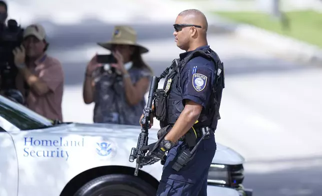 A Department of Homeland Security officer blocks traffic as a prisoner transport van prepares to leave the Paul G. Rogers Federal Building and U.S. Courthouse, where a man suspected in an apparent assassination attempt targeting former President Donald Trump, was charged with federal gun crimes, Monday, Sept. 16, 2024, in West Palm Beach, Fla. (AP Photo/Wilfredo Lee)