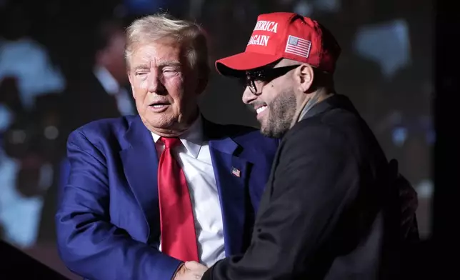 Republican presidential nominee former President Donald Trump, left, greets Nicky Jam during a campaign event at the World Market Center, Friday, Sept.13, 2024, in Las Vegas. (AP Photo/Alex Brandon)