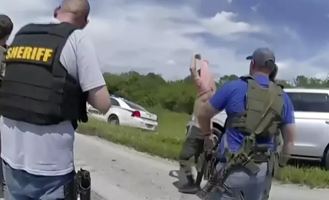 In this image taken from police body camera video and released by the Martin County, Fla., Sheriff’s Office, law enforcement officers prepare to arrest Ryan Routh, the man suspected in the apparent assassination attempt of Donald Trump, Sunday, Sept. 15, 2024. (Martin County Sheriff’s Office via AP)