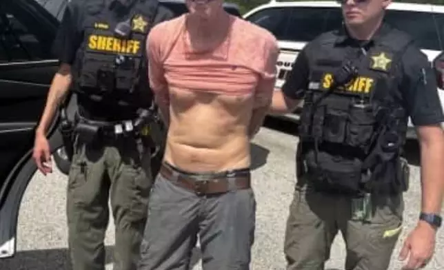 In this imaged released by the Martin County, Fla., Sheriff’s Office, law enforcement officers arrest Ryan Routh, the man suspected in the apparent assassination attempt of Donald Trump, Sunday, Sept. 15, 2024. (Martin County Sheriff’s Office via AP)