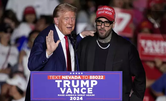 Republican presidential nominee former President Donald Trump, left, greets Nicky Jam during a campaign event at the World Market Center, Friday, Sept.13, 2024, in Las Vegas. (AP Photo/John Locher)