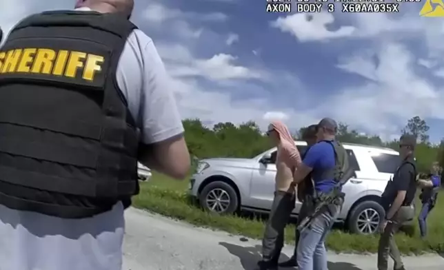 In this image taken from police body camera video and released by the Martin County, Fla., Sheriff’s Office, law enforcement officers arrest Ryan Routh, the man suspected in the apparent assassination attempt of Donald Trump, Sunday, Sept. 15, 2024. (Martin County Sheriff’s Office via AP)