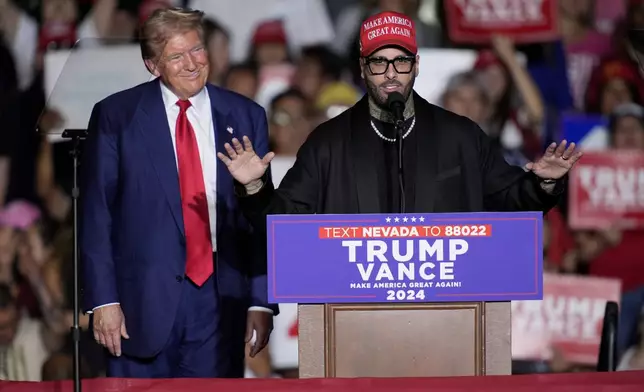 Nicky Jam speaks as Republican presidential nominee former President Donald Trump listens during a campaign event at the World Market Center, Friday, Sept.13, 2024, in Las Vegas. (AP Photo/John Locher)