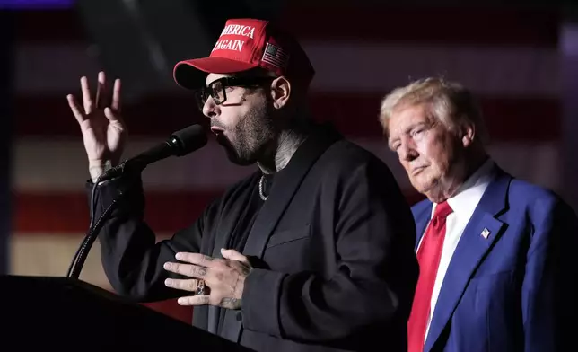 Nicky Jam speaks as Republican presidential nominee former President Donald Trump listens during a campaign event at the World Market Center, Friday, Sept.13, 2024, in Las Vegas. (AP Photo/Alex Brandon)