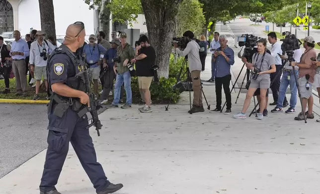 A Department of Homeland Security officer, left, prepares to block traffic for a prisoner transport van at the Paul G. Rogers Federal Building and U.S. Courthouse, where a man suspected in an apparent assassination attempt targeting former President Donald Trump, was charged with federal gun crimes, Monday, Sept. 16, 2024, in West Palm Beach, Fla. (AP Photo/Wilfredo Lee)