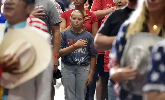 People stand for the Pledge of Allegiance before Republican presidential nominee former President Donald Trump speaks during a campaign event, Friday, Aug. 30, 2024, in Johnstown, Pa. (AP Photo/Alex Brandon)