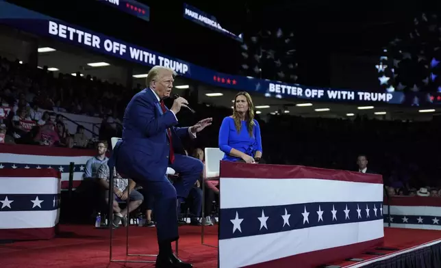 Republican presidential candidate former President Donald Trump, left, on stage with Arkansas Gov. Sarah Huckabee Sanders, right, during a town hall event at the Dort Financial Center, Tuesday, Sept. 17, 2024, in Flint, Mich. (AP Photo/Evan Vucci)