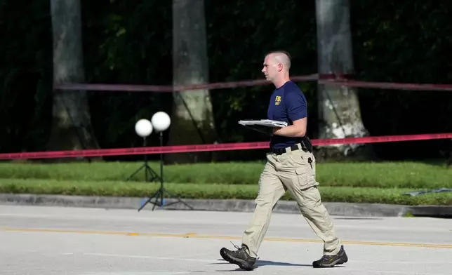 An FBI officer works outside of Trump International Golf Club after the apparent assassination attempt of Republican presidential nominee and former President Donald Trump Monday, Sept. 16, 2024, in West Palm Beach, Fla. (AP Photo/Lynne Sladky)