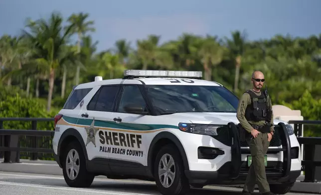 Police stand watch along a road leading to the Mar-a-Lago estate of Republican presidential nominee and former President Donald Trump, one day after an apparent assassination attempt, in Palm Beach, Fla., Monday, Sept. 16, 2024. (AP Photo/Rebecca Blackwell)