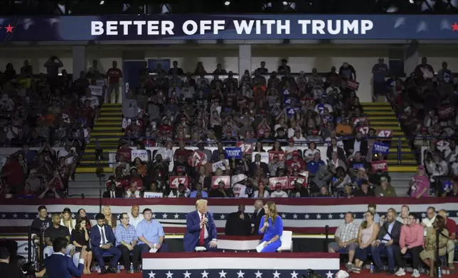 Republican presidential candidate former President Donald Trump, left, on stage with Arkansas Gov. Sarah Huckabee Sanders, right, during a town hall event at the Dort Financial Center, Tuesday, Sept. 17, 2024, in Flint, Mich. (AP Photo/Paul Sancya)