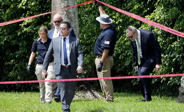 Law enforcement officials work outside of the Trump International Golf Club after the apparent assassination attempt of Republican presidential nominee and former President Donald Trump Monday, Sept. 16, 2024, in West Palm Beach, Fla. (AP Photo/Lynne Sladky)