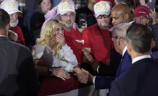 Jessica Sands, 18, of Holly, Mich., cries as she shakes hands with Republican presidential nominee former President Donald Trump at a town hall campaign event at Macomb Community College, Friday, Sept. 27, 2024, in Warren, Mich. (AP Photo/Alex Brandon)