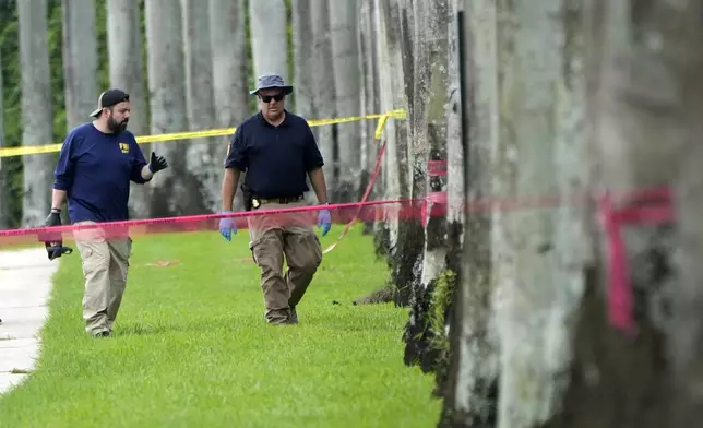 Law enforcement officials work outside of the Trump International Golf Club after the apparent assassination attempt of Republican presidential nominee and former President Donald Trump Monday, Sept. 16, 2024, in West Palm Beach, Fla. (AP Photo/Lynne Sladky)