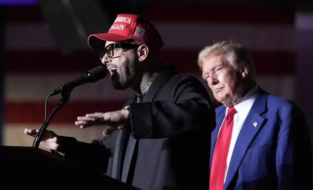 Nicky Jam speaks as Republican presidential nominee former President Donald Trump listens during a campaign event at the World Market Center, Friday, Sept.13, 2024, in Las Vegas. (AP Photo/Alex Brandon)