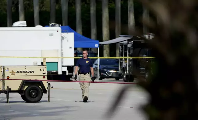 An FBI officer works outside of Trump International Golf Club after the apparent assassination attempt of Republican presidential nominee and former President Donald Trump Monday, Sept. 16, 2024, in West Palm Beach, Fla. (AP Photo/Lynne Sladky)