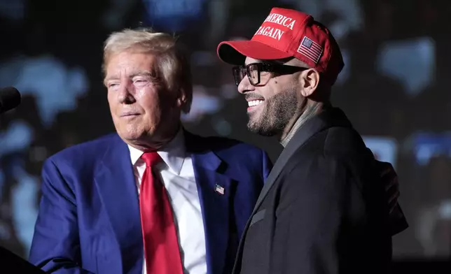 Republican presidential nominee former President Donald Trump, left, greets Nicky Jam during a campaign event at the World Market Center, Friday, Sept.13, 2024, in Las Vegas. (AP Photo/Alex Brandon)