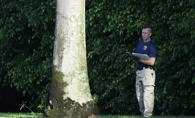 An FBI officer works outside of Trump International Golf Club after the apparent assassination attempt of Republican presidential nominee and former President Donald Trump Monday, Sept. 16, 2024, in West Palm Beach, Fla. (AP Photo/Lynne Sladky)