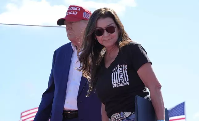 Gretchen Wilson walks off stage after speaking at a campaign event for Republican presidential nominee former President Donald Trump, seen at left, at Central Wisconsin Airport, Saturday, Sept. 7, 2024, in Mosinee, Wis. (AP Photo/Alex Brandon)