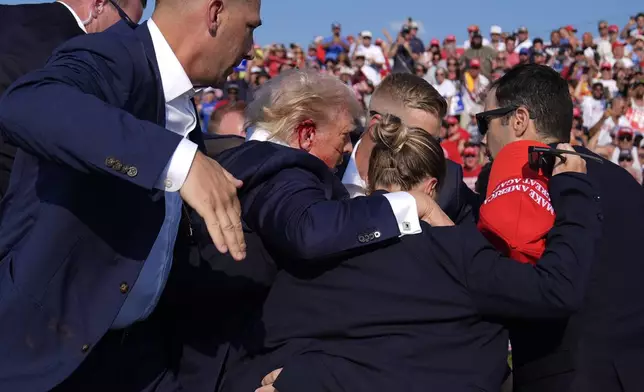 FILE - Republican presidential candidate former President Donald Trump is surrounded by U.S. Secret Service agents at a campaign rally, July 13, 2024, in Butler, Pa. (AP Photo/Evan Vucci, File)