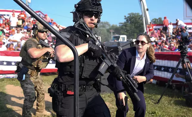 FILE - U.S. Secret Service agents respond as Republican presidential candidate former President Donald Trump is surrounded on stage by U.S. Secret Service agents at a campaign rally, July 13, 2024, in Butler, Pa. (AP Photo/Evan Vucci, File)