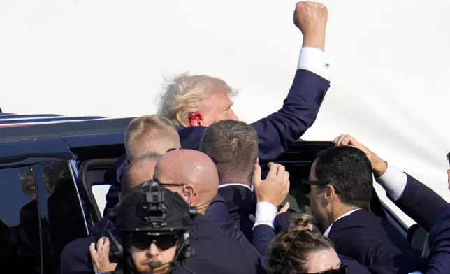 FILE - Republican presidential candidate former President Donald Trump pumps his fist as he is escorted into a vehicle at a campaign event in Butler, Pa., July 13, 2024. (AP Photo/Gene J. Puskar, File)