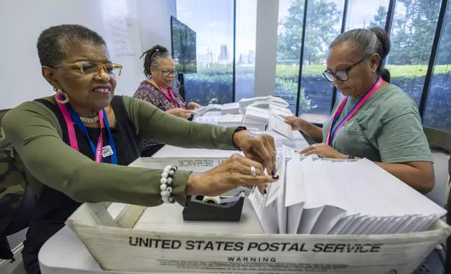 left to right; Carol Hamilton, Cristo Carter and Cynthia Huntley prepare ballots to be mailed at the Mecklenburg County Board of Elections in Charlotte, N.C., Thursday, Sept. 5, 2024. (AP Photo/Nell Redmond)