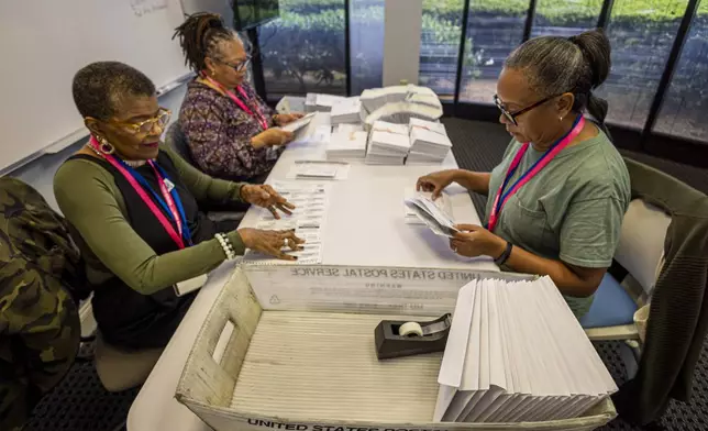 Left to right; Carol Hamilton, Cristo Carter and Cynthia Huntley prepare ballots at the Mecklenburg County Board of Elections in Charlotte, N.C., Thursday, Sept. 5, 2024. (AP Photo/Nell Redmond)