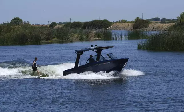 Grant Jeide wake surfs behind an electric sports boat made by California-based Arc Boats on the Sacramento-San Joaquin Delta near Bethel Island, Calif. on Wednesday, July 31, 2024. (AP Photo/Terry Chea)