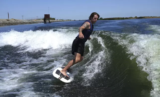 Grant Jeide wake surfs behind an electric sports boat made by California-based Arc Boats on the Sacramento-San Joaquin Delta near Bethel Island, Calif. on Wednesday, July 31, 2024. (AP Photo/Terry Chea)