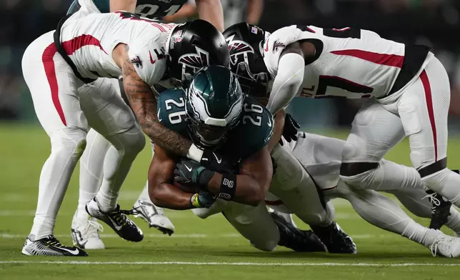 Philadelphia Eagles running back Saquon Barkley (26) is brought down during the first half of an NFL football game by Atlanta Falcons' Jessie Bates III, left, on Monday, Sept. 16, 2024, in Philadelphia. (AP Photo/Matt Slocum)