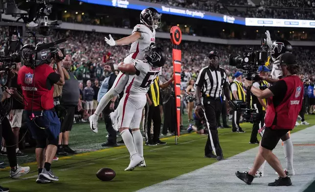 Atlanta Falcons wide receiver Drake London (5) celebrates his touchdown with Atlanta Falcons guard Chris Lindstrom (63) during the second half of an NFL football game against the Philadelphia Eagles on Monday, Sept. 16, 2024, in Philadelphia. (AP Photo/Matt Rourke)