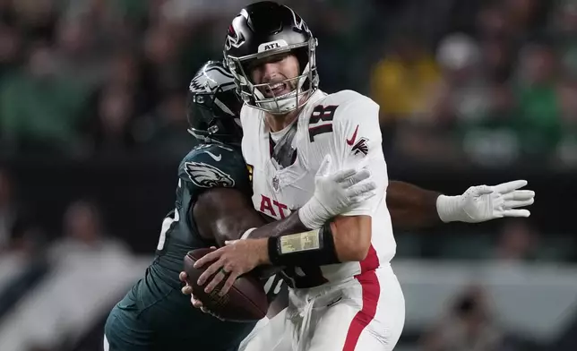 Atlanta Falcons quarterback Kirk Cousins is stopped by Philadelphia Eagles defensive end Brandon Graham (55) during the first half of an NFL football game Monday, Sept. 16, 2024, in Philadelphia. (AP Photo/Matt Rourke)