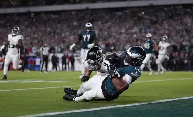 Philadelphia Eagles running back Saquon Barkley (26) catches a pass in front of Atlanta Falcons safety Jessie Bates III (3) during the second half of an NFL football game Monday, Sept. 16, 2024, in Philadelphia. (AP Photo/Matt Slocum)