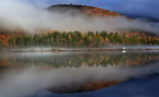 FILE - A railroad worker inspects the tracks behind his truck alongside the Androsscoggin River as a storm clears to reveal colorful fall foliage, Oct. 29, 2015, near Gorham, N.H. (AP Photo/Robert F. Bukaty, File)