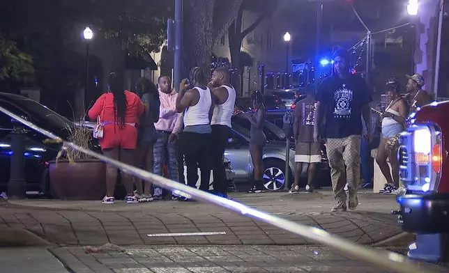 This image provided by WBMA shows bystanders near the scene of a shooting in Birmingham, Ala., Sunday, Sept. 22, 2024. (Bill Castle/WBMA via AP)