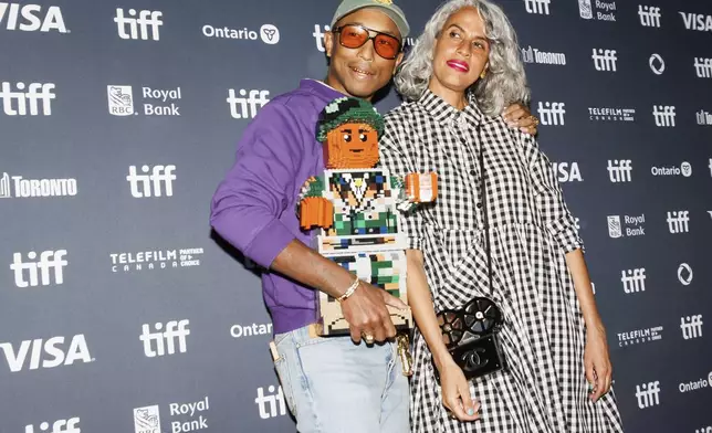 Pharrell Williams and Mimi Valdez arrive on the red carpet for the premiere of 'Piece by Piece' at the Princess of Wales Theatre during the Toronto International Film Festival in Toronto, Tuesday, Sept. 10, 2024. (Cole Burston/The Canadian Press via AP)