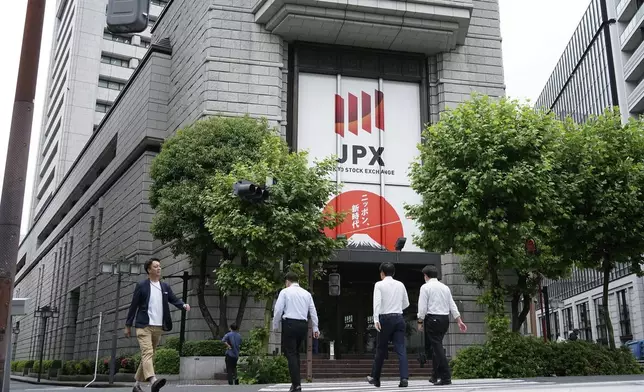 FILE - People walk in front of Tokyo Stock Exchange building in Tokyo, on May 28, 2024. (AP Photo/Eugene Hoshiko, File)