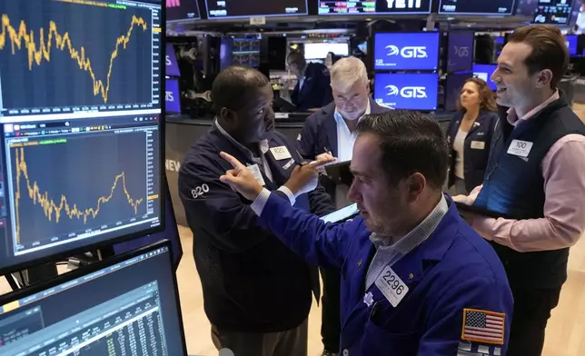 Specialist Genaro Saporito, foreground, works with traders at his post on the floor of the New York Stock Exchange, Wednesday, Sept. 18, 2024. (AP Photo/Richard Drew)