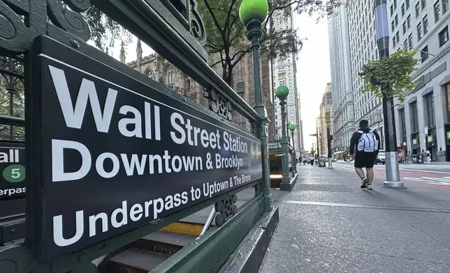 People pass the entrance for the Wall Street subway station on Tuesday, Sept. 2, 2024, in New York. (AP Photo/Peter Morgan)