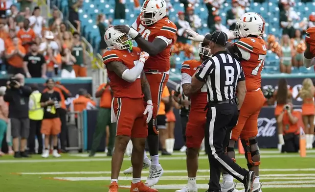 Miami tight end Elijah Arroyo, left, celebrates with offensive lineman Markel Bell, second from left, after after scoring a touchdown during the first half of an NCAA football game, Saturday, Sept. 7, 2024, in Miami Gardens, Fla. (AP Photo/Lynne Sladky)