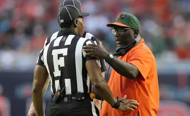 Florida A&amp;M head coach James Colzie III, right, talks with an official during the first half of an NCAA football game against Miami, Saturday, Sept. 7, 2024, in Miami Gardens, Fla. (AP Photo/Lynne Sladky)