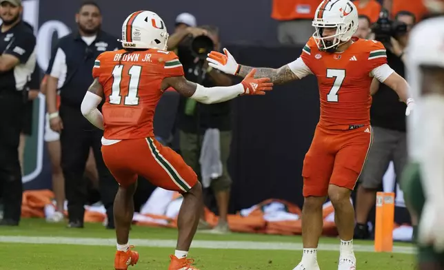 Miami wide receiver Xavier Restrepo (7) celebrates with wide receiver Samuel Brown (11) after scoring a touchdown during the first half of an NCAA football game against Florida A&amp;M, Saturday, Sept. 7, 2024, in Miami Gardens, Fla. (AP Photo/Lynne Sladky)