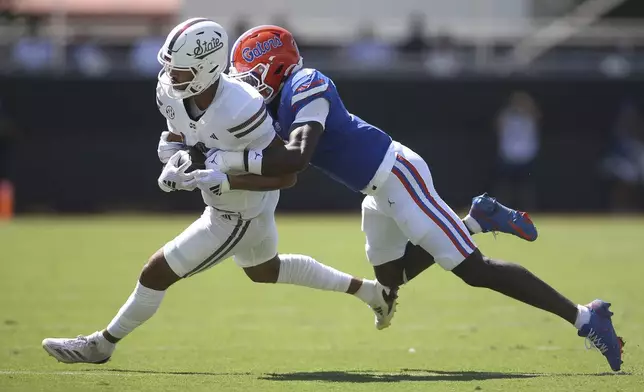 Mississippi State tight end Cameron Ball (10) attempts to break a tackle against Florida defensive back Trikweze Bridges (7) during the first half of an NCAA college football game in Starkville, Miss., Saturday, Sept. 21, 2024. (AP Photo/James Pugh)