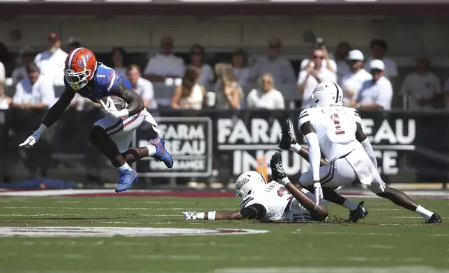 Florida running back Montrell Johnson Jr. (1) goes airborne against Mississippi State safety Brylan Lanier (3) and Mississippi State cornerback Kelley Jones (1) during the first half of an NCAA college football game in Starkville, Miss., Saturday, Sept. 21, 2024. (AP Photo/James Pugh)