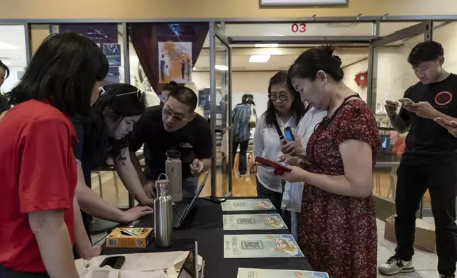 Members of the Las Vegas Asian community receive information on how to vote in Chinese during the annual Dragon Boat Festival in Las Vegas, Wednesday, June 5, 2024. Advocates are working to help non-English speakers access voting materials in their primary language. (Christopher Lomahquahu/News21 via AP)