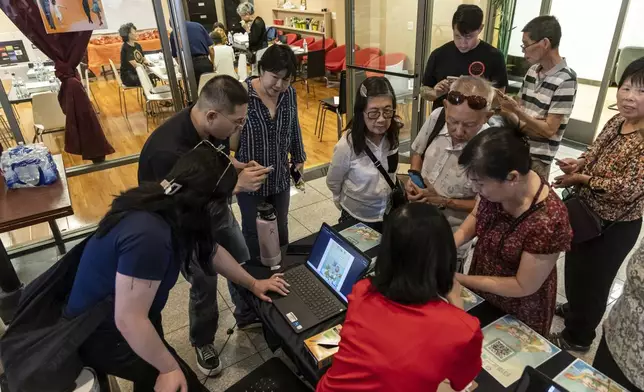 Members of the Las Vegas Asian community receive information on how to vote in Chinese during the annual Dragon Boat Festival in Las Vegas, Wednesday, June 5, 2024. Advocates are working to help non-English speakers access voting materials in their primary language. (Christopher Lomahquahu/News21 via AP)