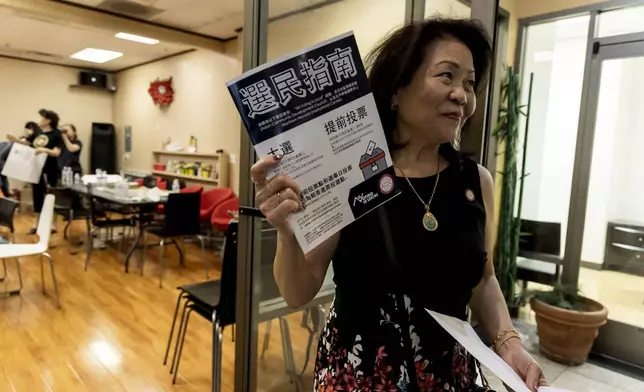 Vida Lin, president and founder of the Asian Community Development Council, holds a voter information booklet her group translated into Chinese during the annual Dragon Boat Festival in Las Vegas, Wednesday, June 5, 2024. (Christopher Lomahquahu/News21 via AP)