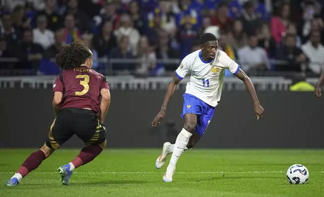 France's Ousmane Dembele, right, prepares to take a shot scoring his side's second goal as Belgium's Arthur Theate tries to stop him during the UEFA Nations League soccer match between France and Belgium at the Groupama stadium in Decines, outside Lyon, France, Monday, Sept. 9, 2024. (AP Photo/Laurent Cipriani)