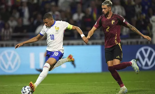 France's Kylian Mbappe, left, controls the ball as Belgium's Zeno Debast tries to stop him during the UEFA Nations League soccer match between France and Belgium at the Groupama stadium in Decines, outside Lyon, France, Monday, Sept. 9, 2024. (AP Photo/Laurent Cipriani)